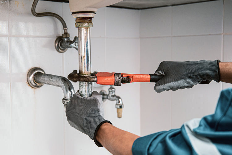 Plumber fixing a leak | Blog | Greystar